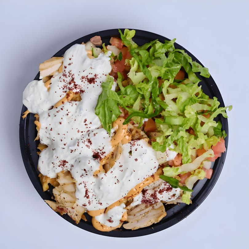 Shawarma Way's chicken shawarma plate with white sauce, red spice, lettuce, and diced tomatoes.